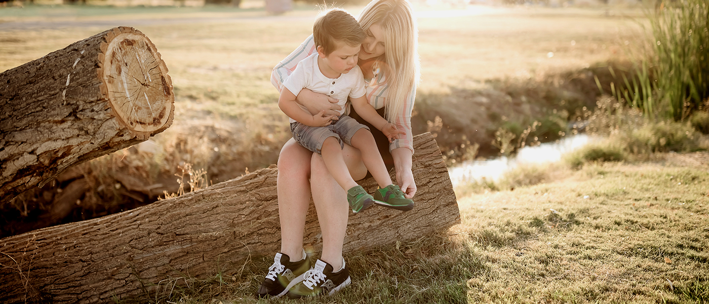 Parent and child sitting on a log.