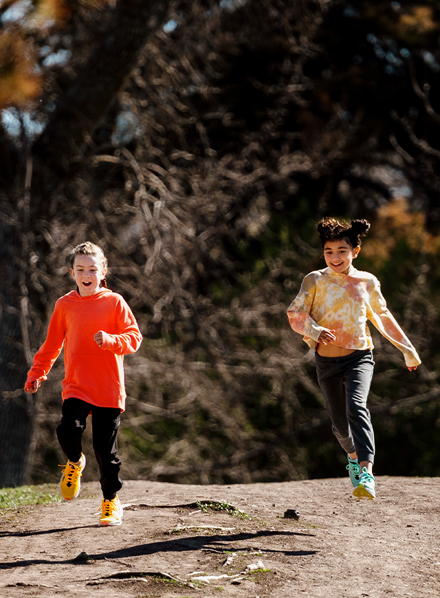 Two kids running in Saucony shoes
