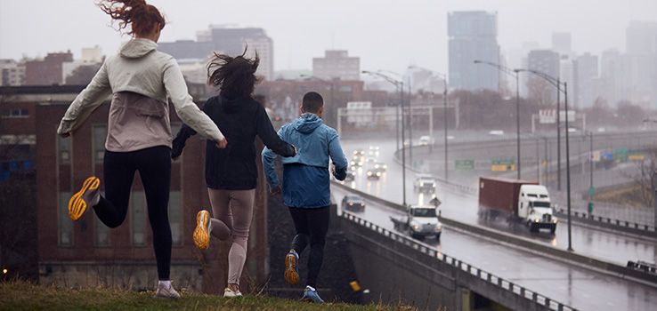 A group of people running on a hill.
