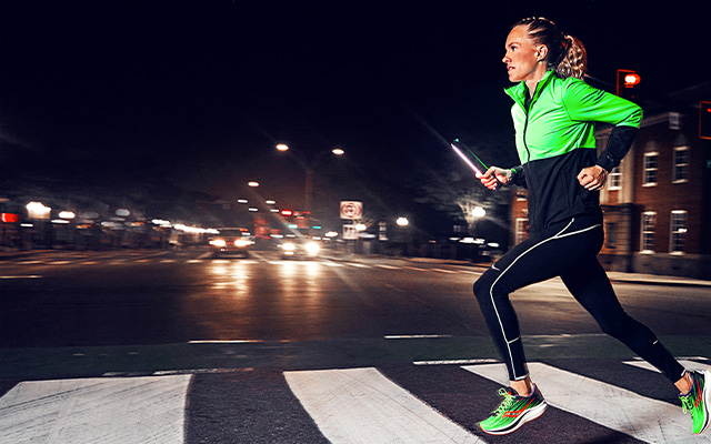 Running over a crosswalk at night wearing bright apparel.