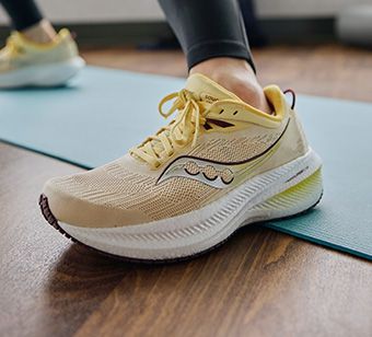 A person's foot on a mat wearing Saucony Ride 17 running shoes.