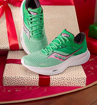 Une paire de chaussures vertes Saucony sur une boîte cadeau.