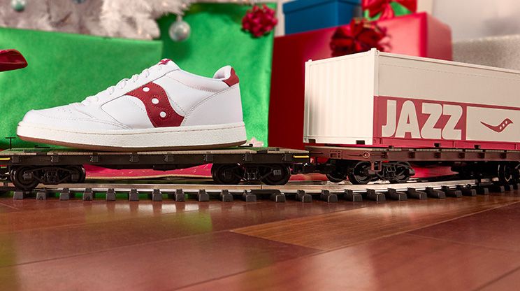 Un train-jouet avec une chaussure Saucony Originals posée dessus.
