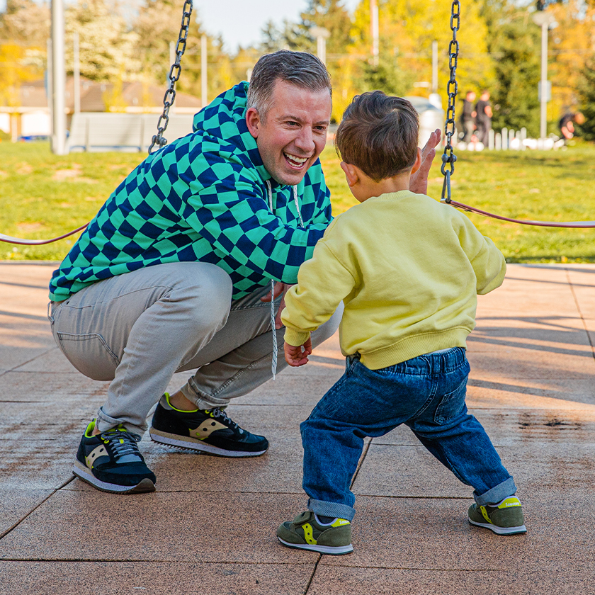 A kid and an adult wearing the same style of shoe.