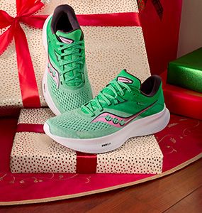 A pair of green Saucony shoes on a gift box.