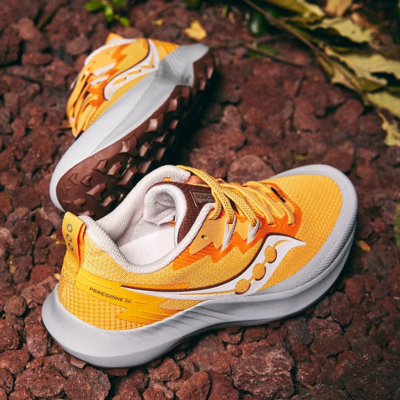A pair of yellow Saucony Peregrine 14 shoes on rocks.