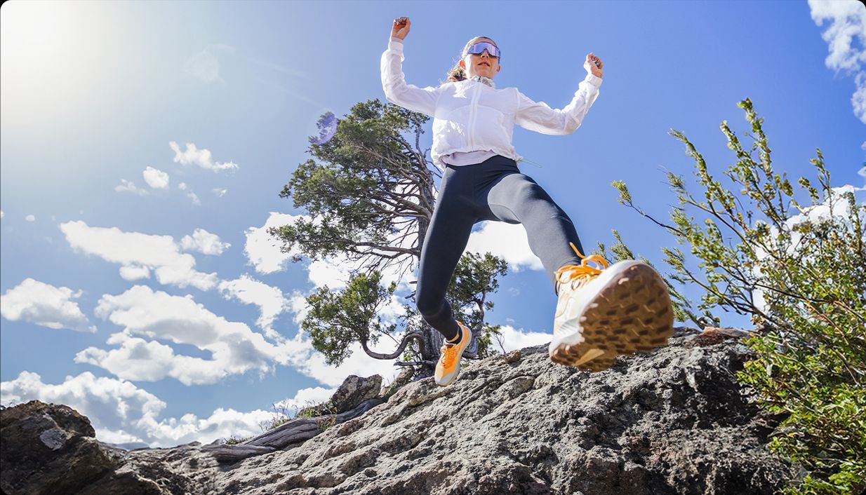 A person jumping up a hill wearing Saucony Peregrine 14.