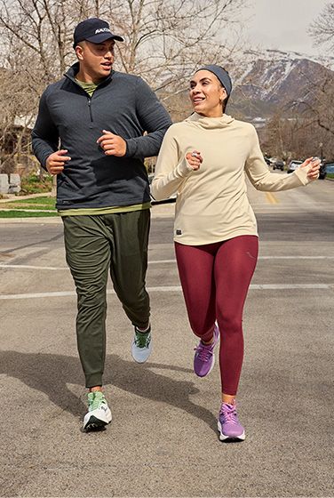 Two people running on a street wearing Saucony gear.