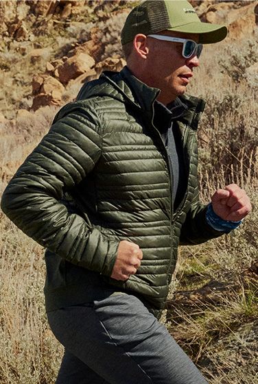 A person running outside wearing Saucony jacket.