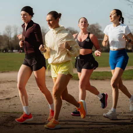 a group of women running on a dirt path