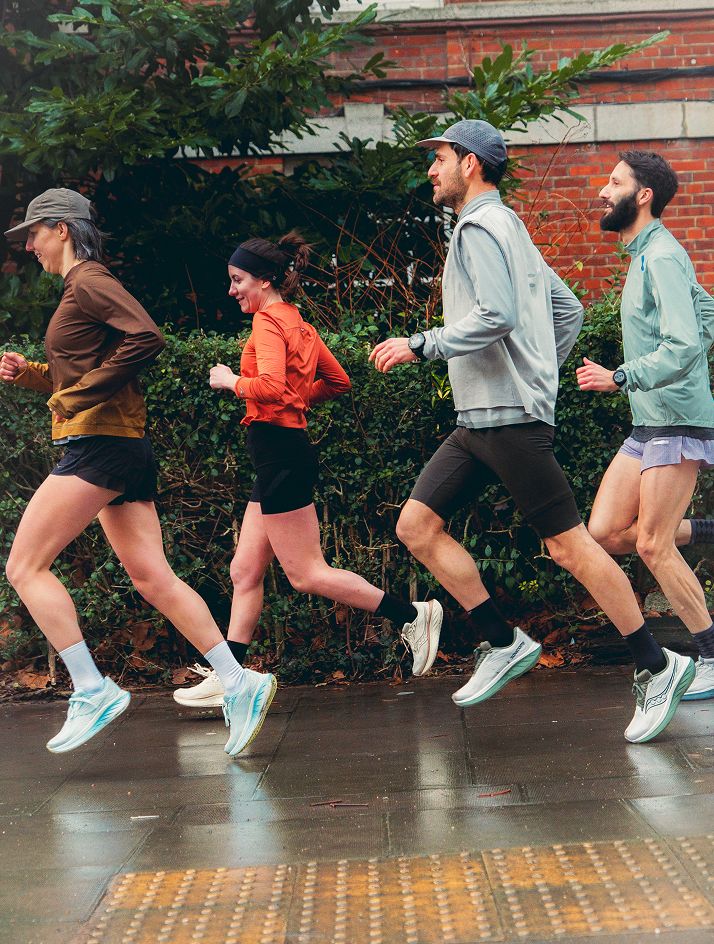 a group of people running on a sidewalk