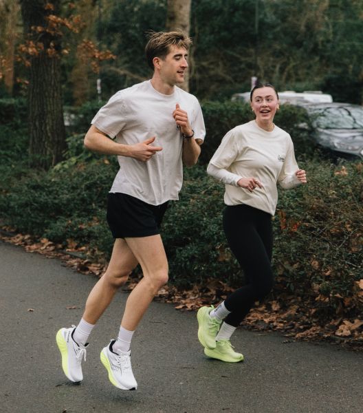 a man and woman running on a road