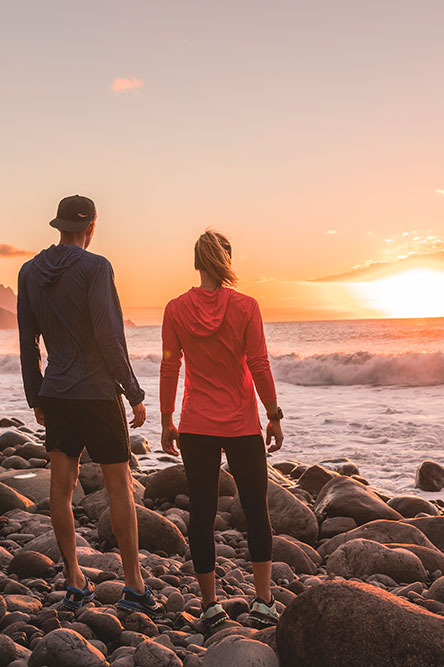 Man and woman on the beach looking into the sunset
