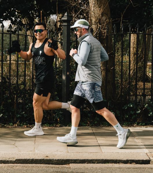 two men running on a sidewalk