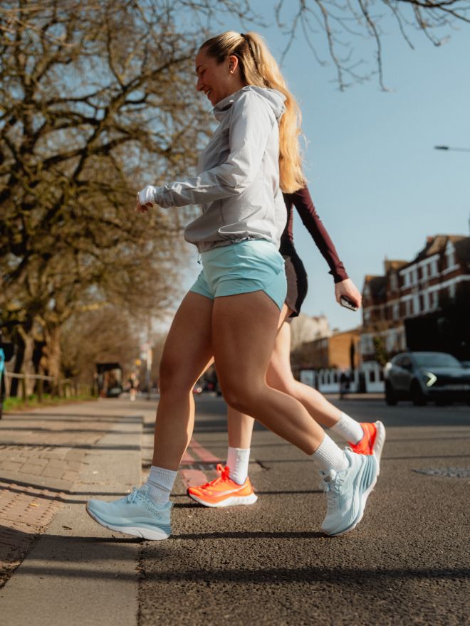 a group of women running on a sidewalk