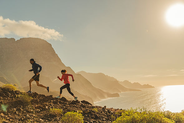 Man and woman running infront of the sunset
