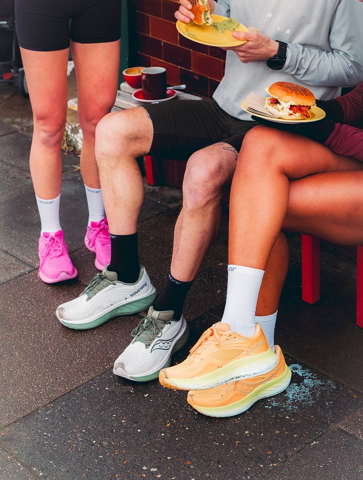 a group of people sitting on a bench eating food