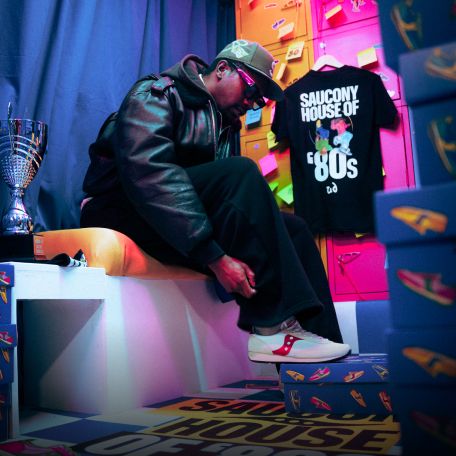 a man sitting on a bench with a trophy and shoes