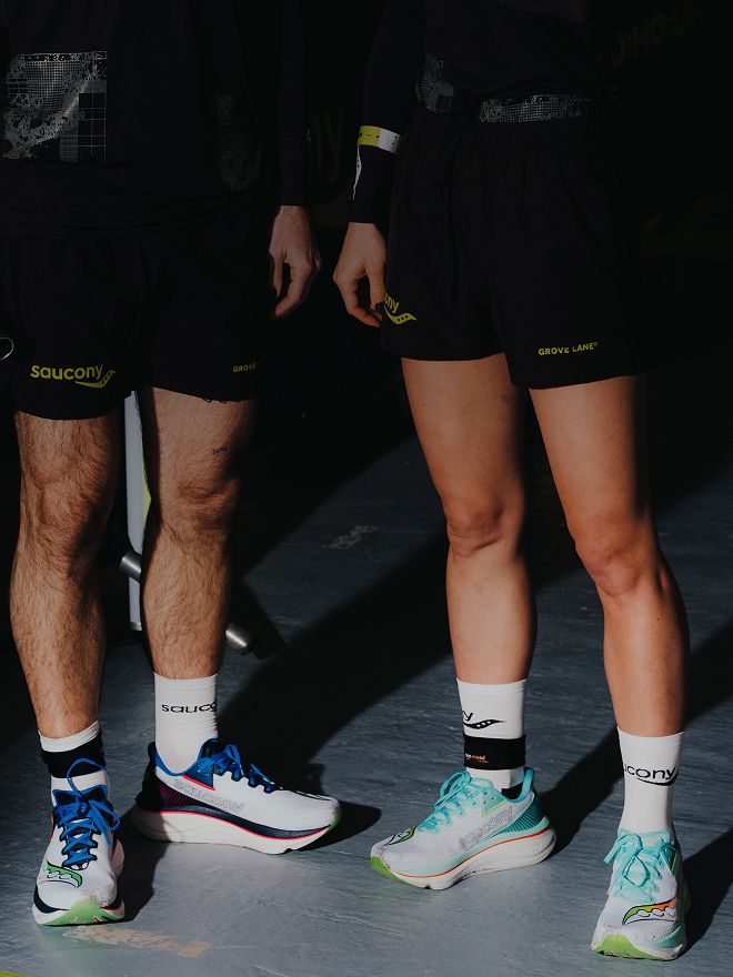 Two athletes standing side by side showcasing Saucony Endorphin Azura running shoes on an indoor surface.