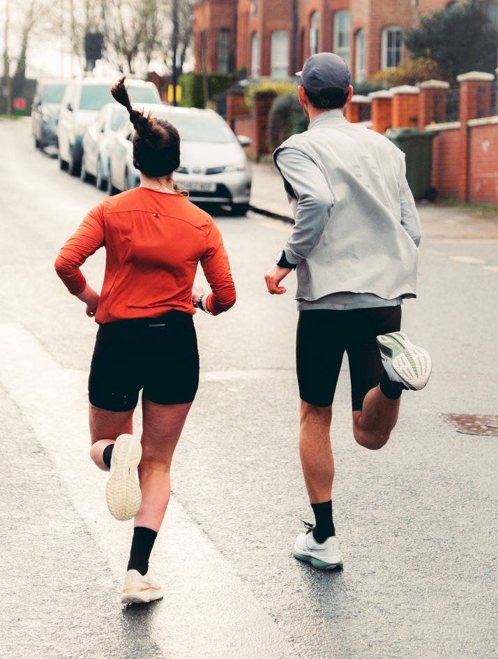 a man and woman running on a street