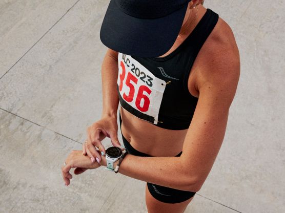 A woman in a sports bra and running cap