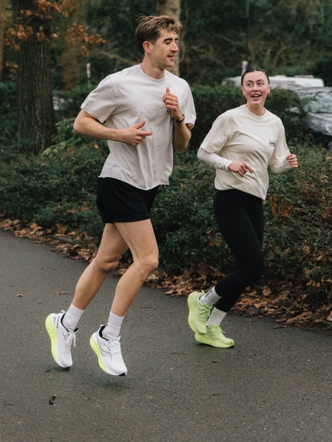 a man and woman running on a road