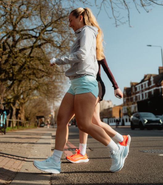 a woman running on a sidewalk