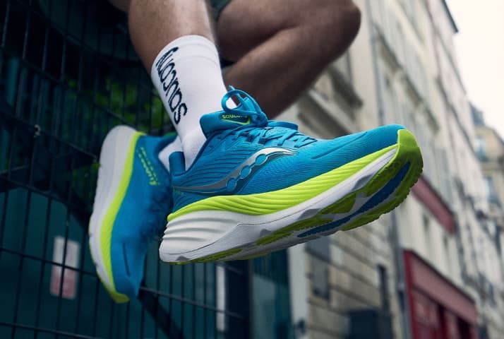 a person's legs in blue and green shoes