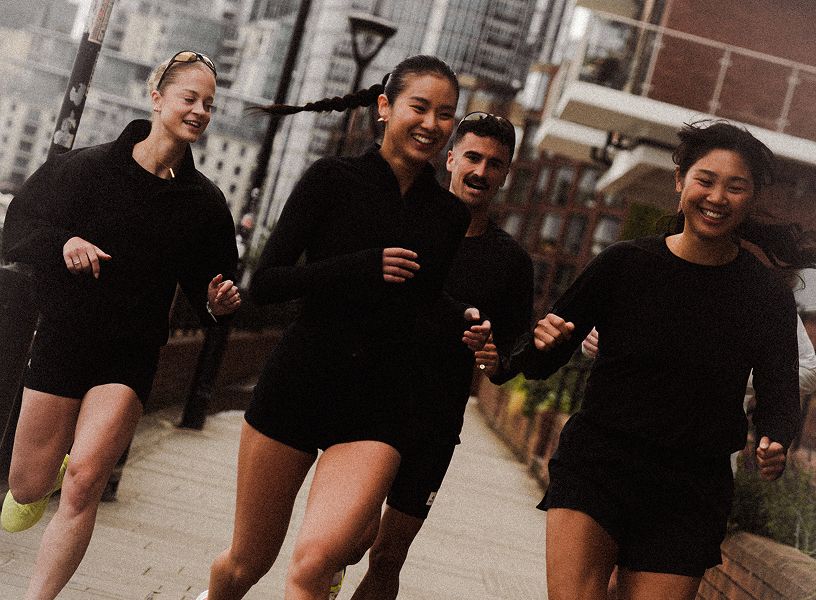 Group of people running in a city wearing Saucony running shoes