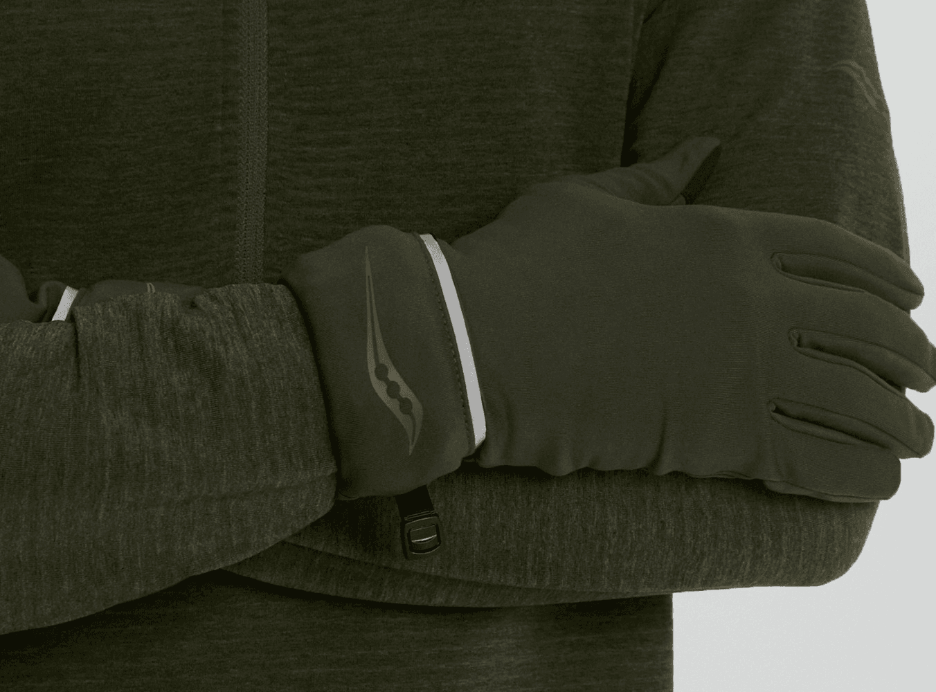 A close-up of a runner wearing Saucony running gloves and a quarter-zip jacket.