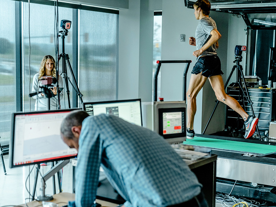 Runner on a treadmill being observed in a lab while testing out Saucony shoes.