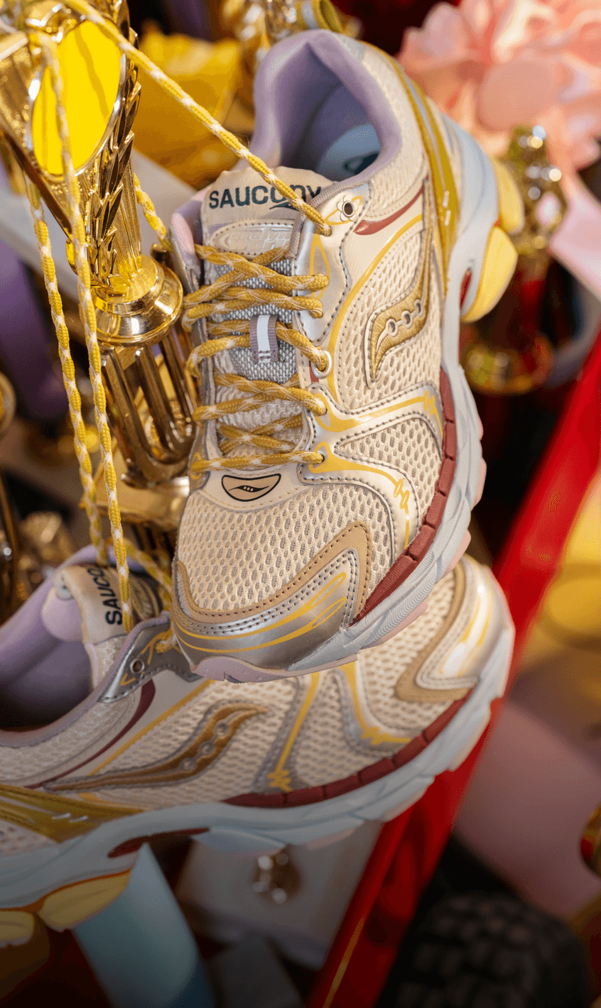 The Evelynn World x Saucony ProGrid Triumph 4 shoes hanging among trophies and ribbons.