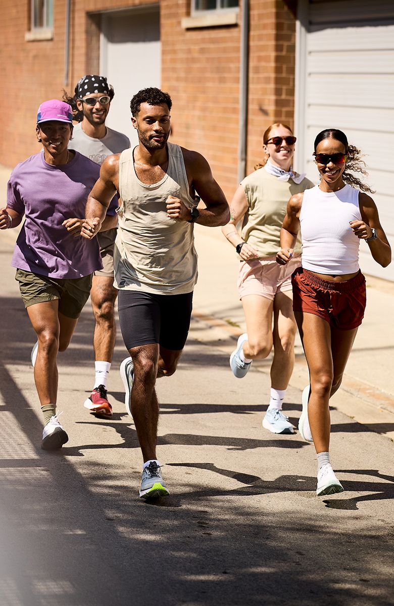 Two people running down the street wearing Saucony gear.