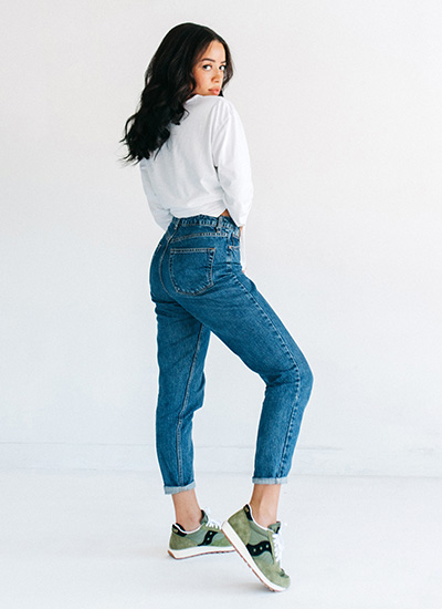 Woman posing in Saucony Jazz Original Shoes and denim jeans.