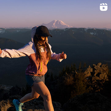 Girl running on mountain wearing Saucony shoes.