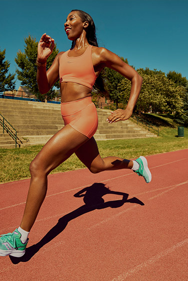 Runner in green Ride 16s on a running track.