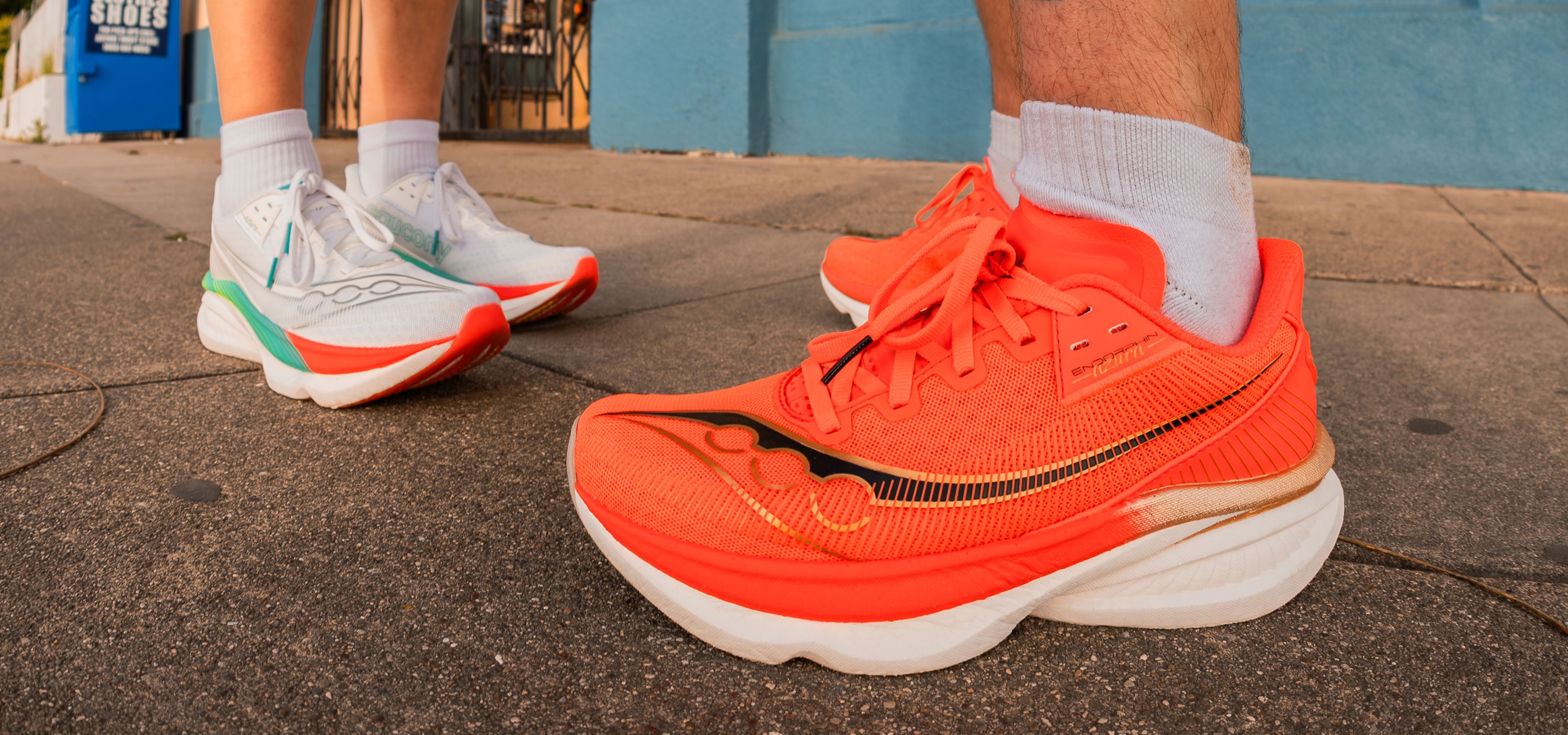 Feet on the street wearing brightly colored shoes.