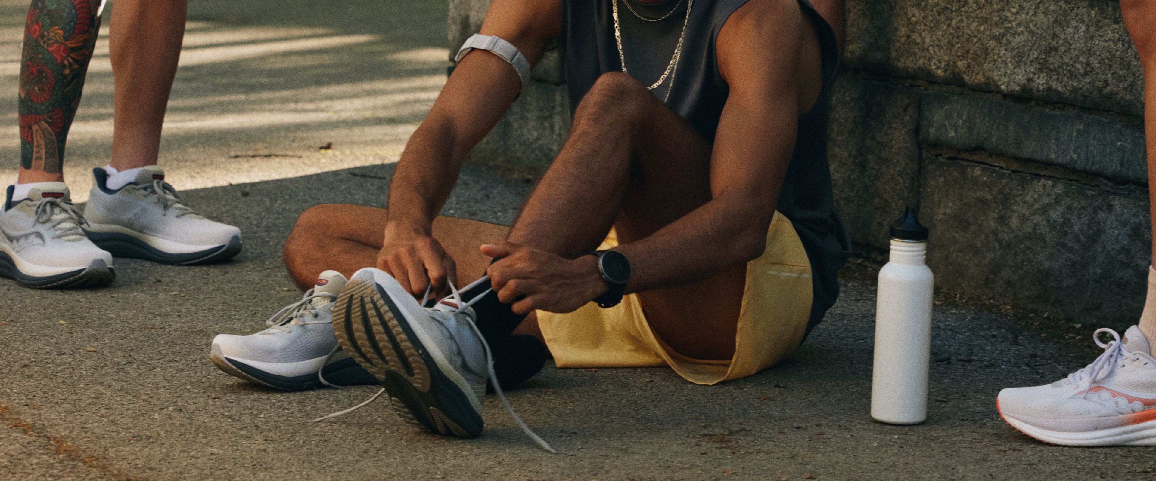 A person tying Saucony shoes.