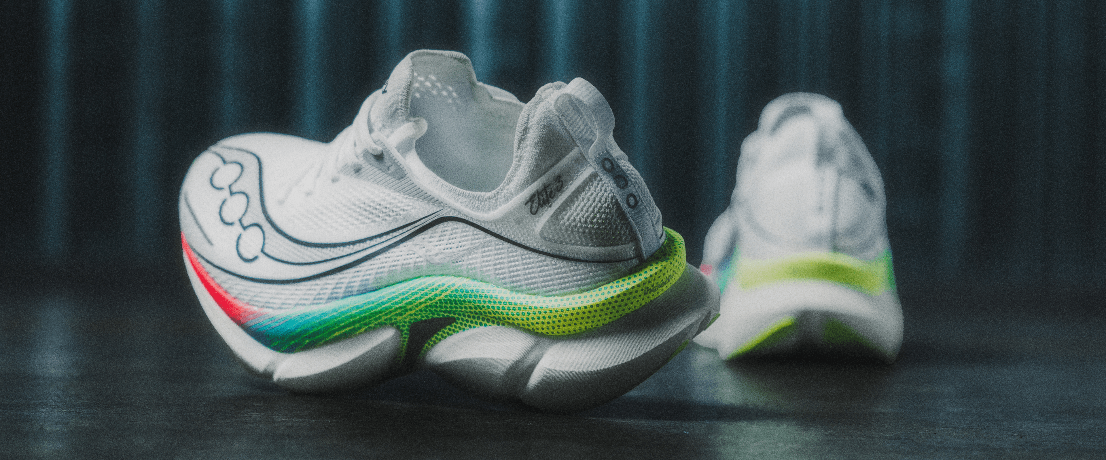 A pair of white Saucony running shoes with a rainbow gradient outsole.