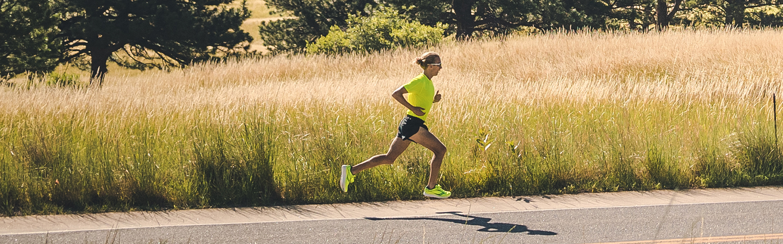 Man running on the road by a field