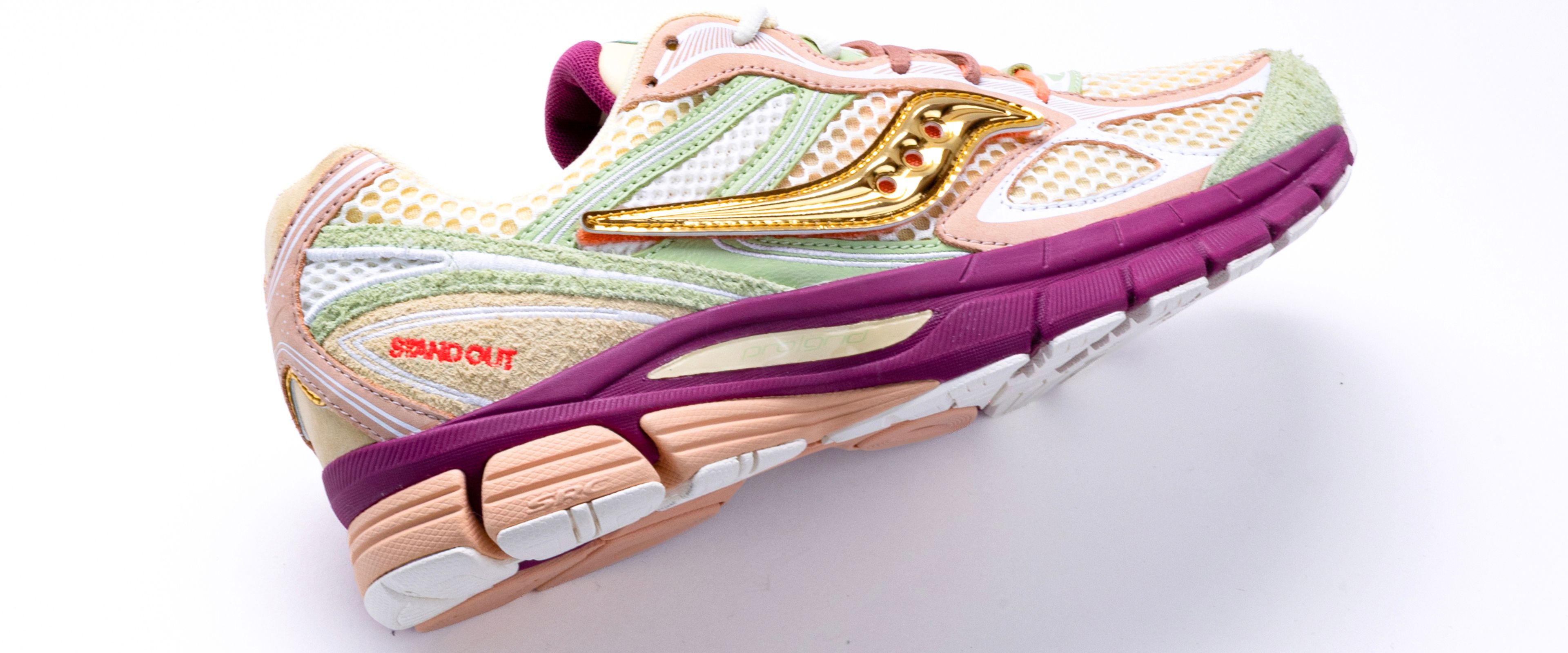 Close-up of the Saucony x Stan Birch ProGrid Guide 7 in cream, sage green and burgundy with metallic gold accents.