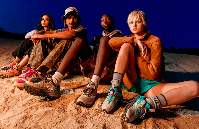 4 people standing on the beach, wearing Saucony Astrotrail shoes.