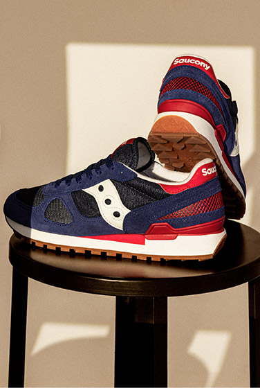 Red, white & blue Shadow sneakers on a stool.