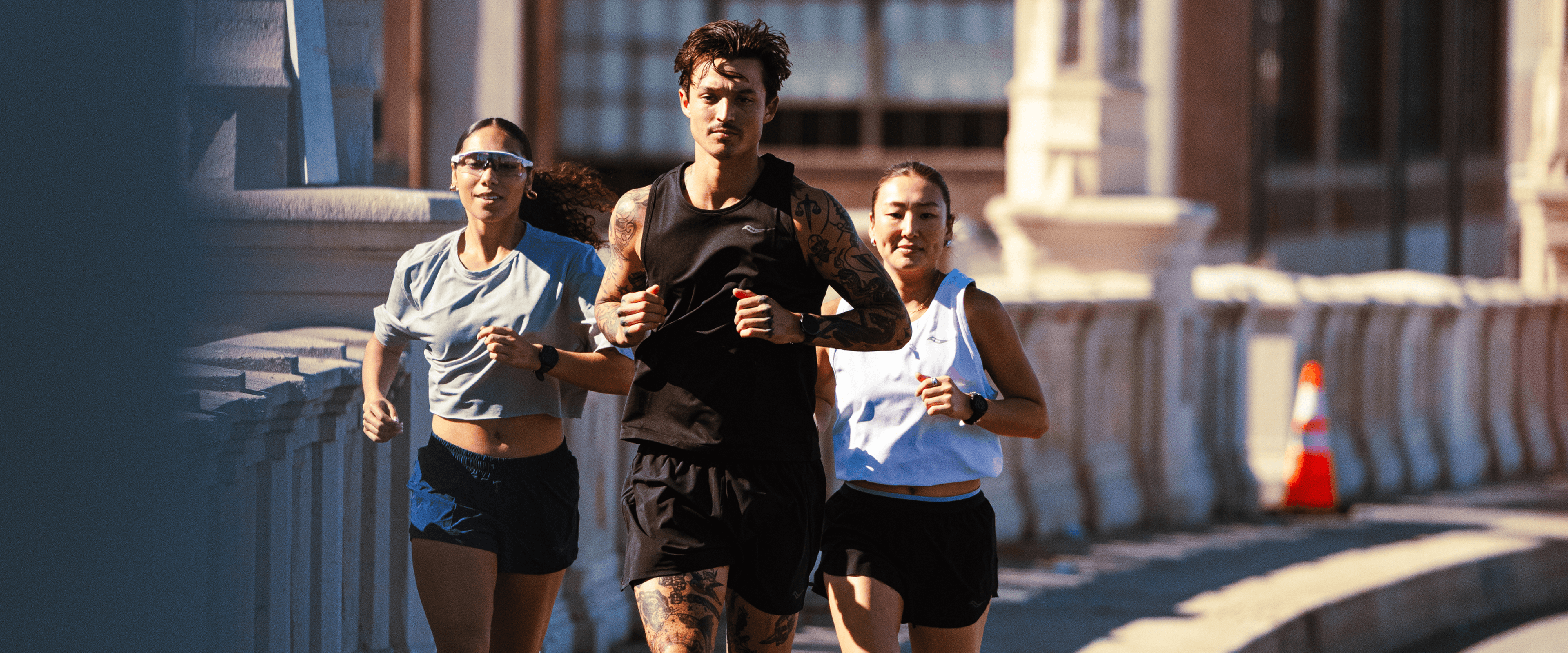 Three runners training together on city streets.