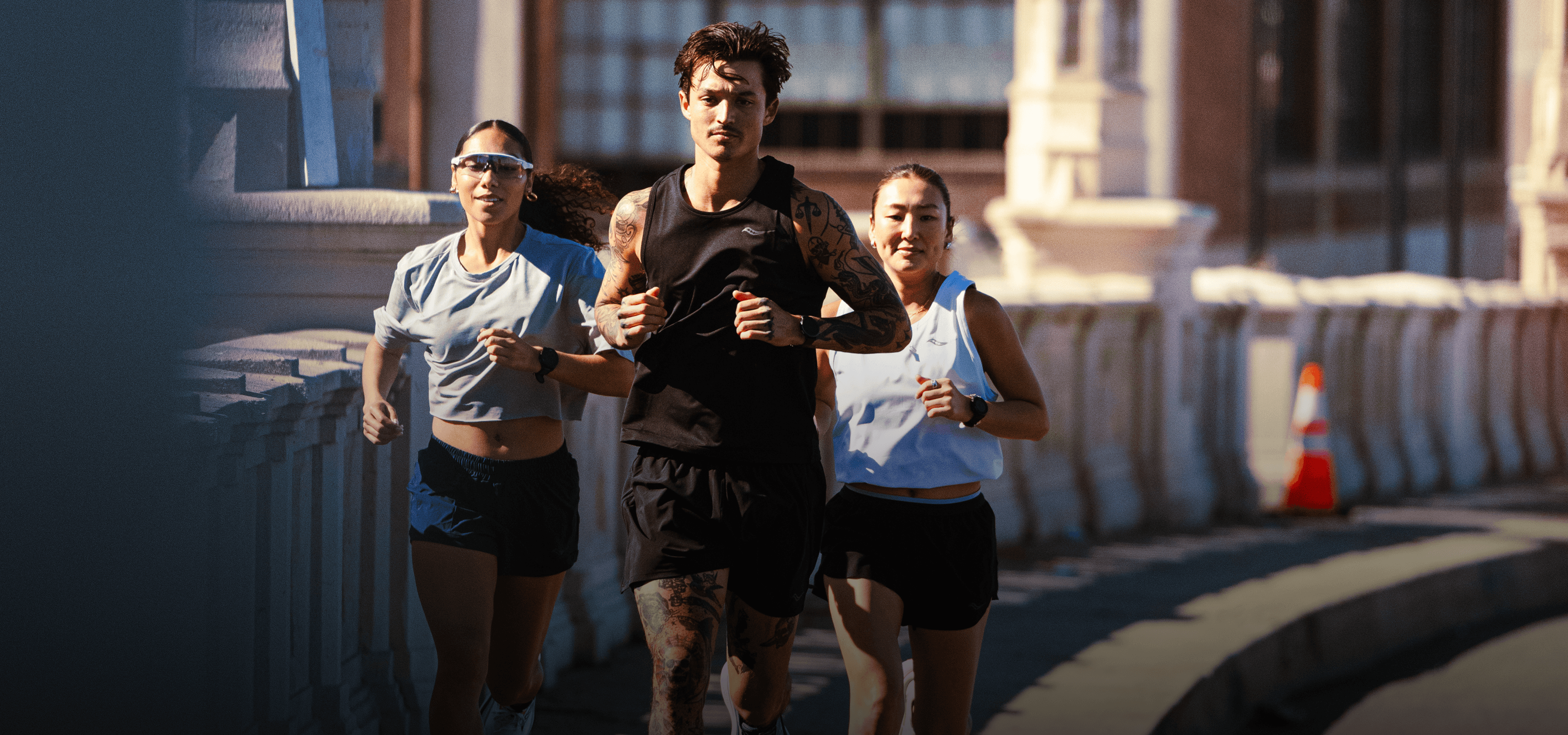 Three runners training together on city streets.
