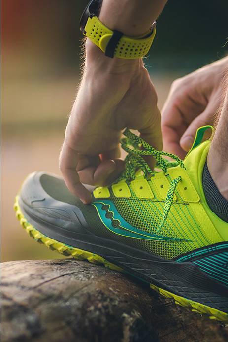 Closeup of Mad River shoe in green getting laced up