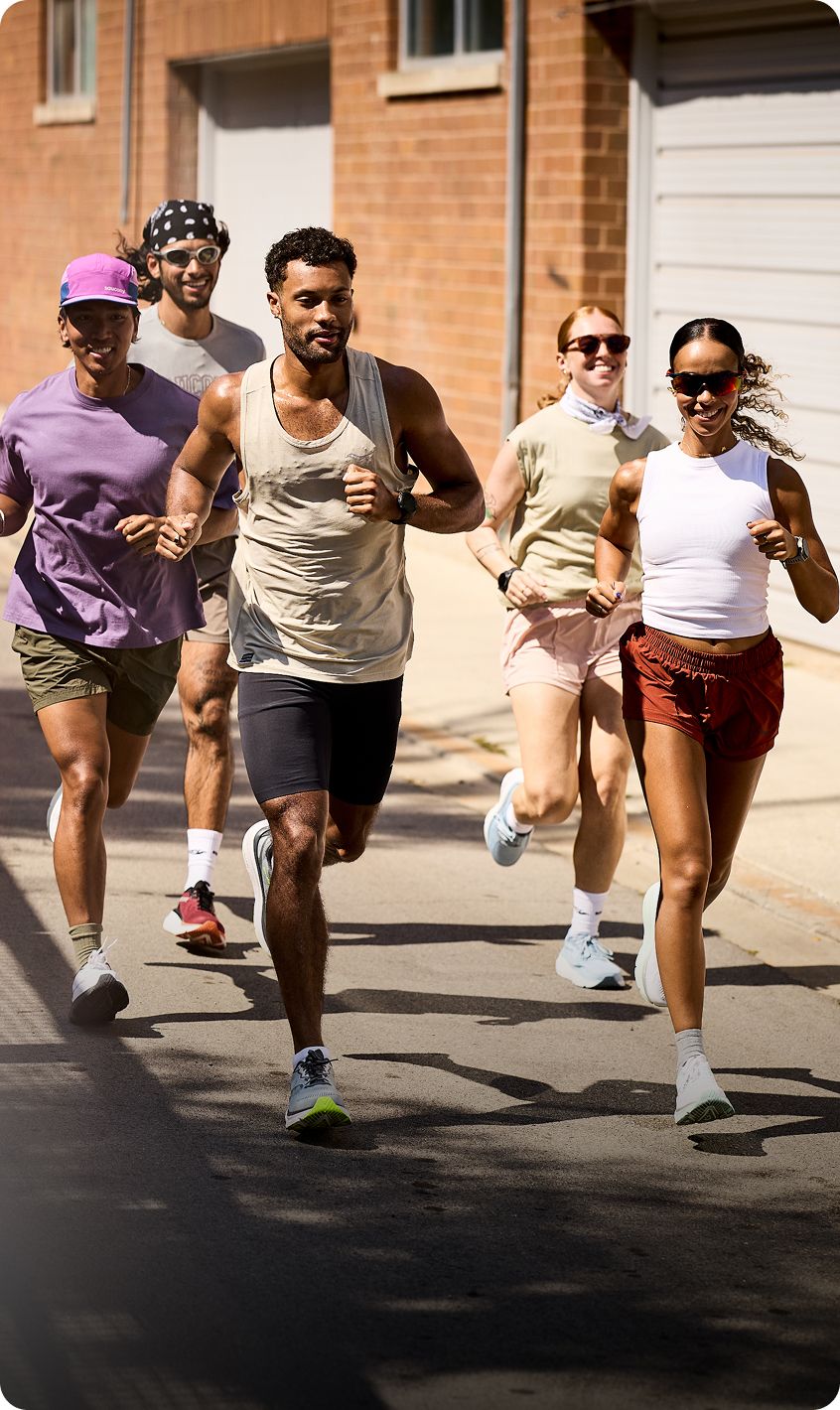 A group of people running down the street.