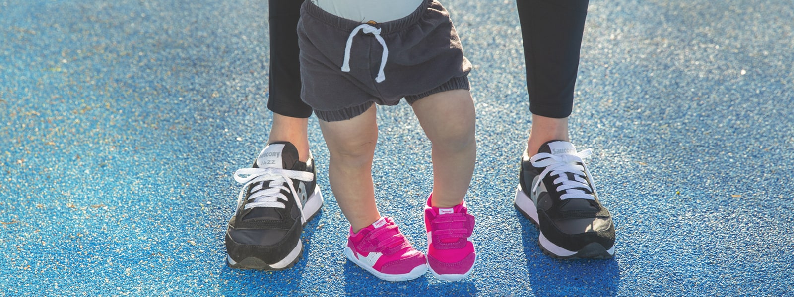 Close of a parents and kids feet, wearing Sauzony Jazz Shoes.