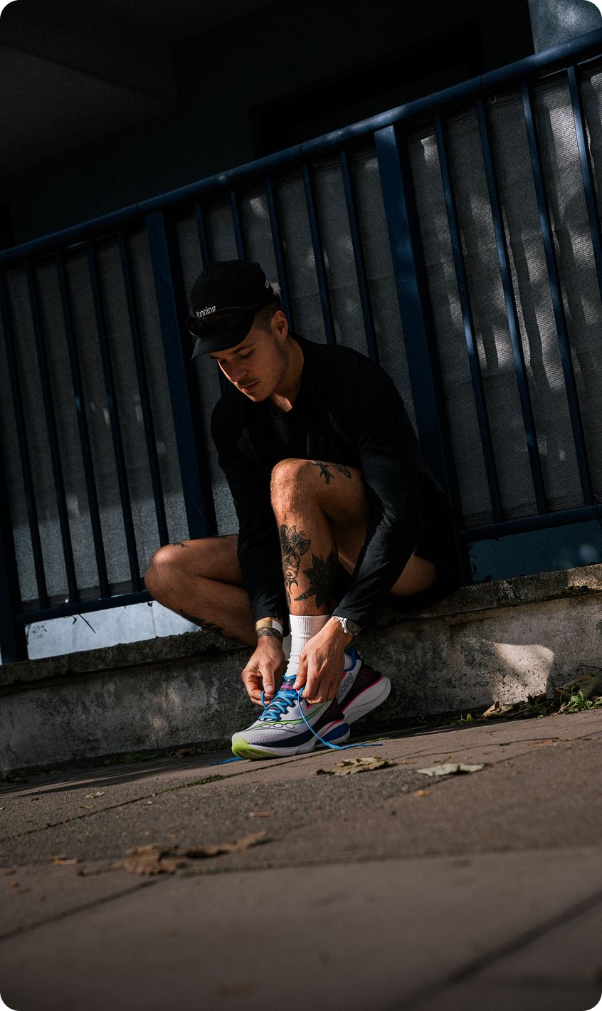 A person lacing up Saucony running shoes.