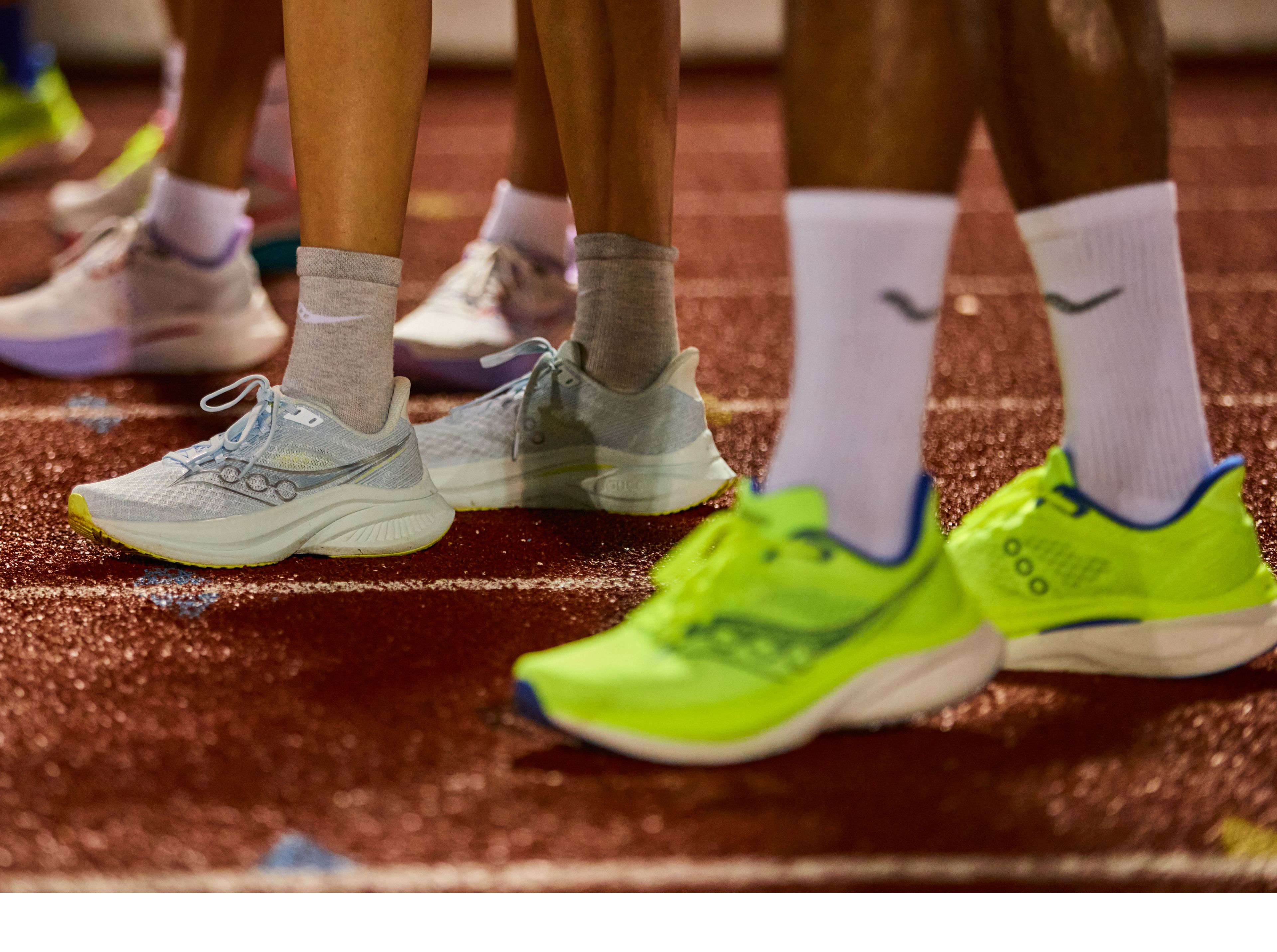 People at a racetrack wearing Saucony shoes